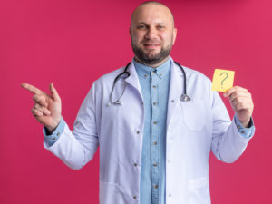 רופא מחזיק דף נייר עם סימן שאלה